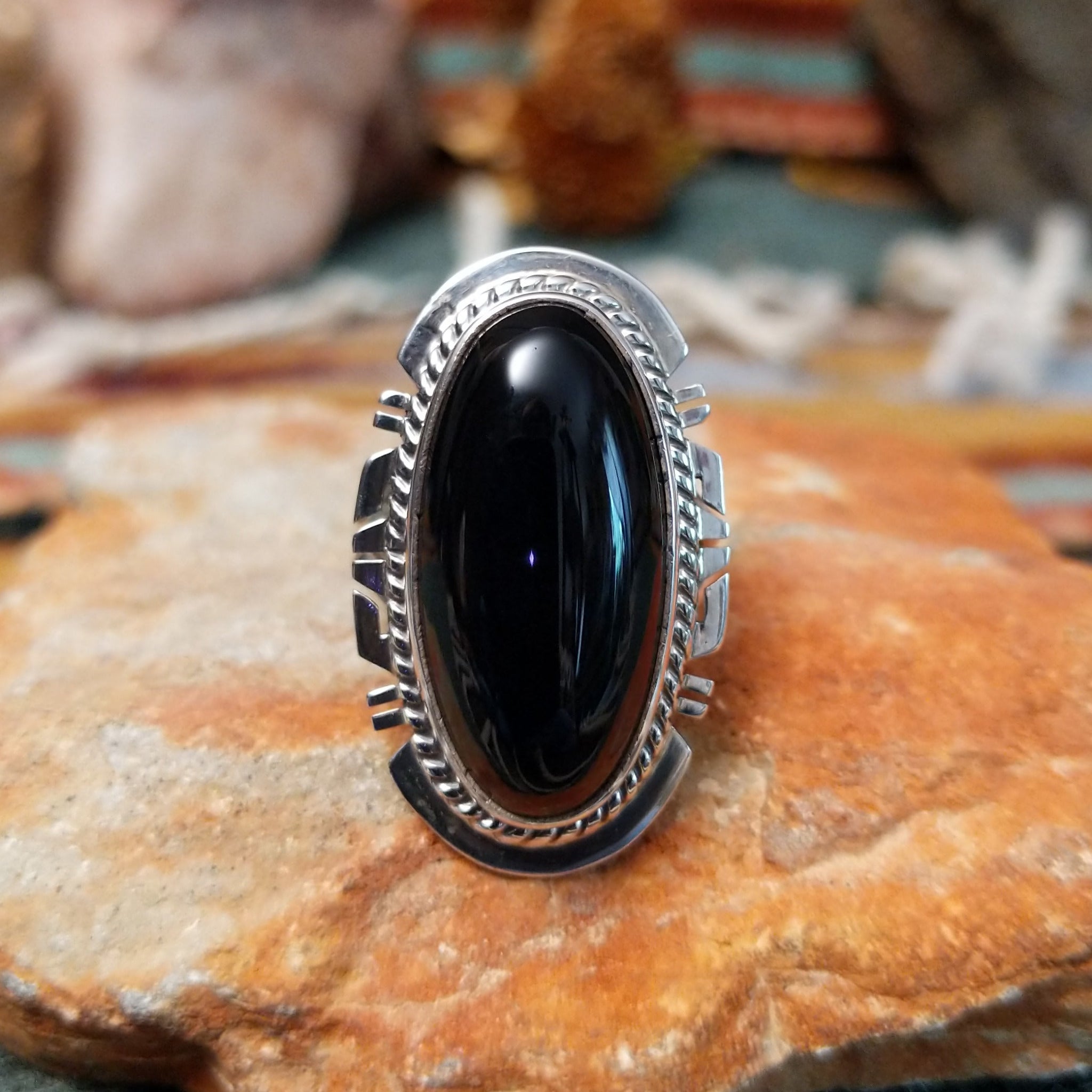 Sterling silver ring by Larson Lee featuring a large elongated oval black onyx cabochon framed by twisted silver rope and geometric silver detailing.
