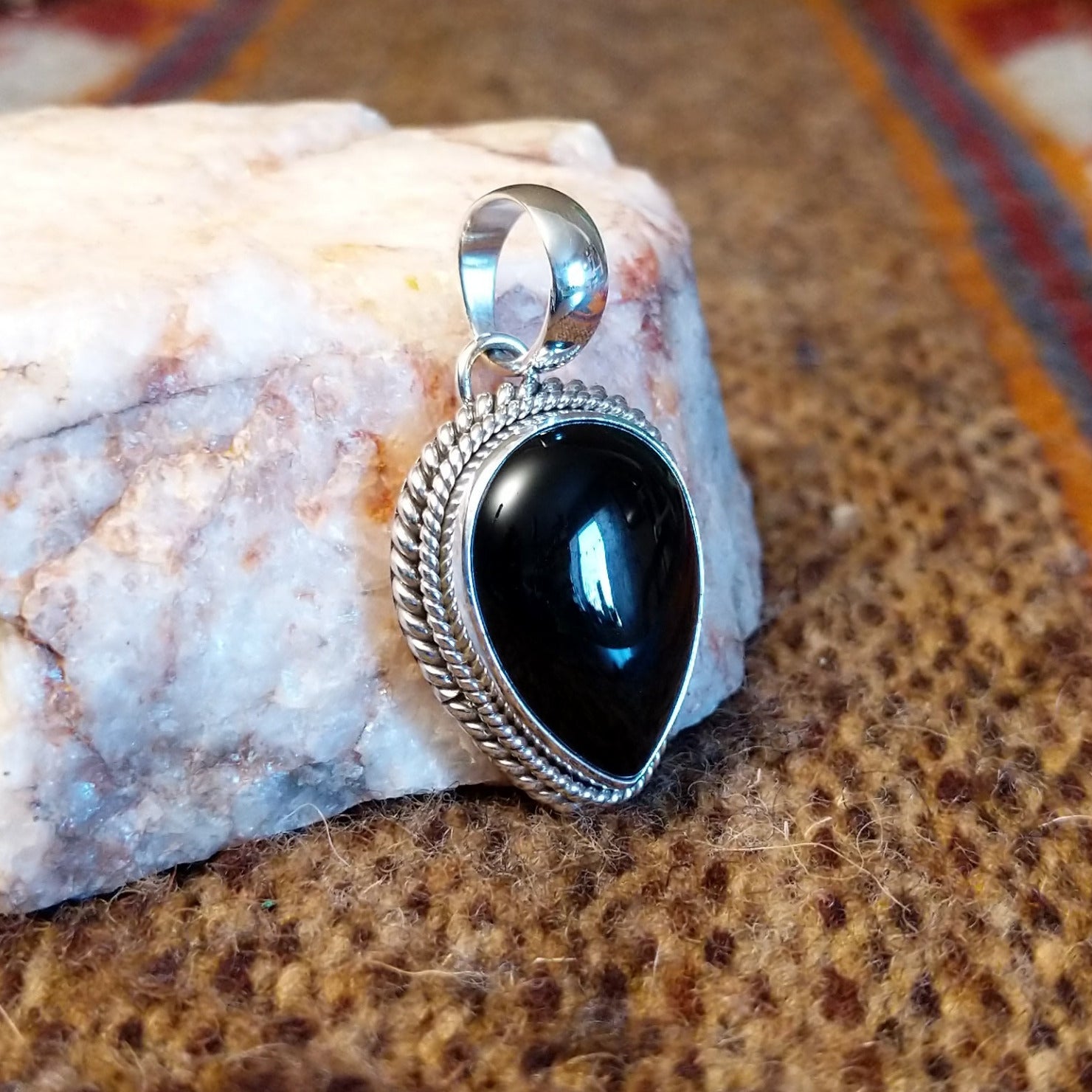 Teardrop shaped pendant with black onyx set in the bezel and framed by twisted rope accents.