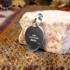 Close-up of the artisan's stamped signature on the back.