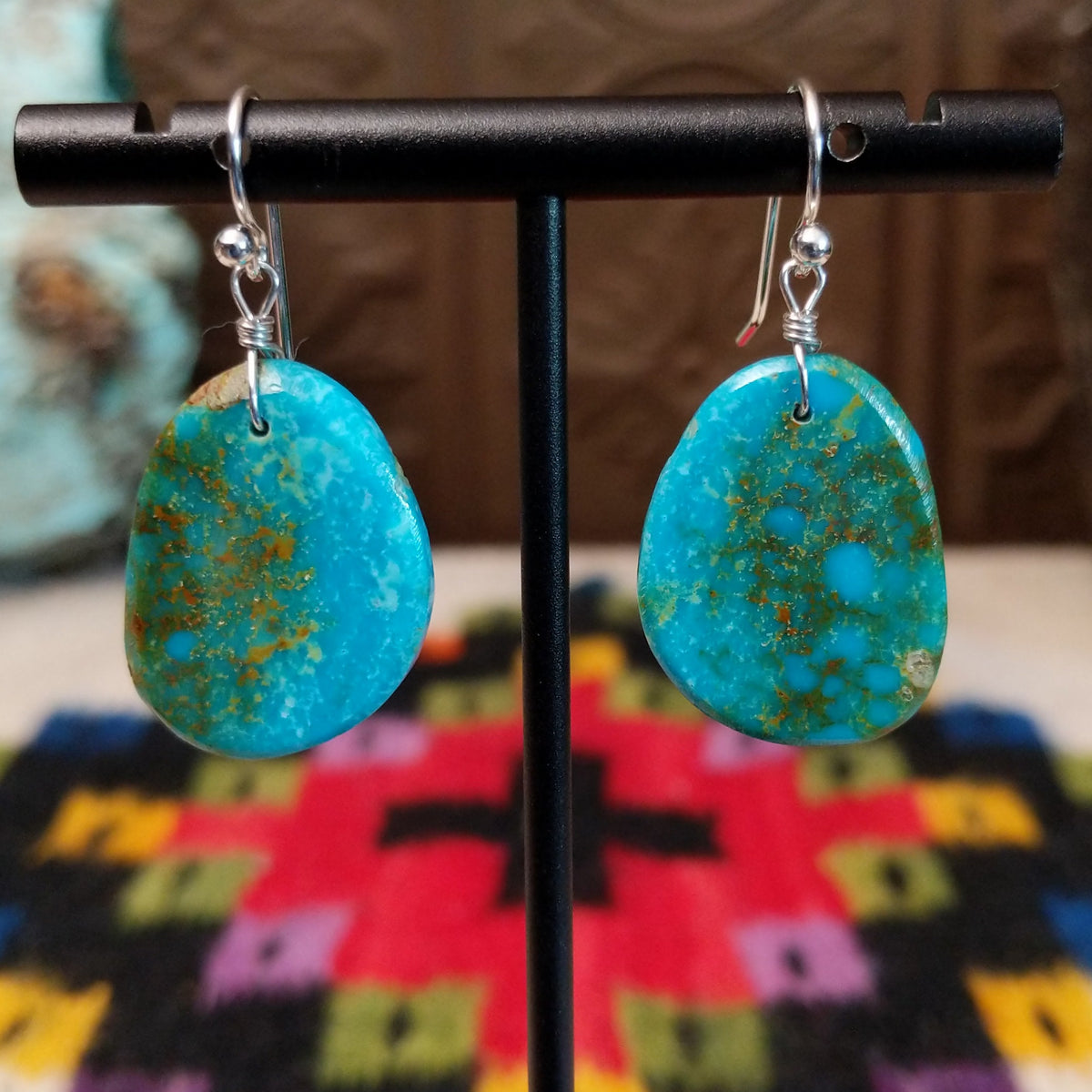 Blue-Green Turquoise Slab Earrings by Ronald Chavez featuring freeform blue-green turquoise stones with natural golden-brown matrix, suspended from silver hooks.