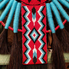 Blue Navajo Bustle artifact reproduction by Linda Lee with beadwork by Dorothy Manning, featuring turquoise, red, black, and white beadwork with dark horsehair accents.