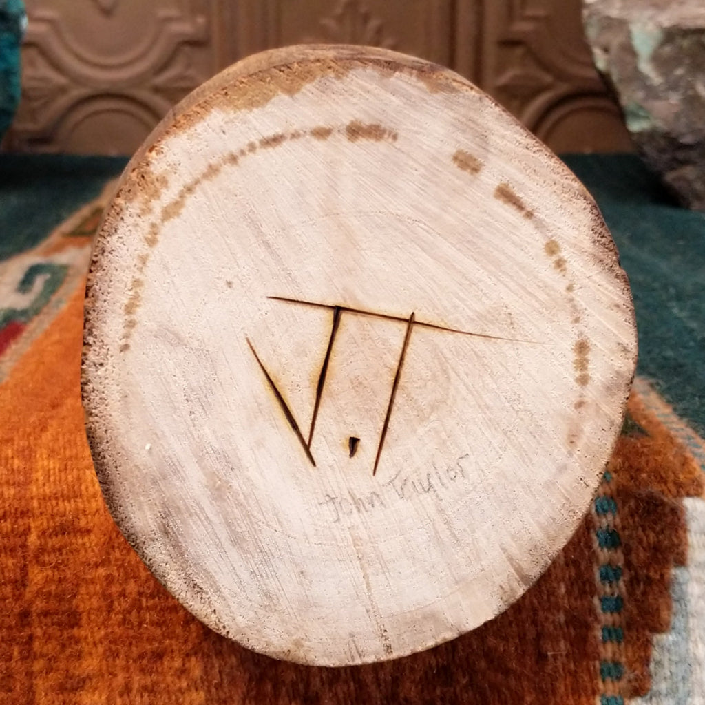 The artisan's signature is found on the base of the piece.