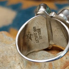 Handcrafted Navajo sterling silver ring by Ann Curley featuring three graduated oval black onyx cabochons in bezel settings with polished silver bead accents on a wide statement band; artisan and Sterling Silver stamp.