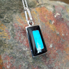 Handcrafted sterling silver turquoise and black onyx inlay pendant by Harlan & Monica Coonsis, featuring a rectangular geometric design; side view.