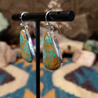 Handcrafted sterling silver teardrop earrings by Lowell Draper featuring natural Boulder Turquoise with vibrant blue coloring and golden-brown matrix on French hooks; side view.