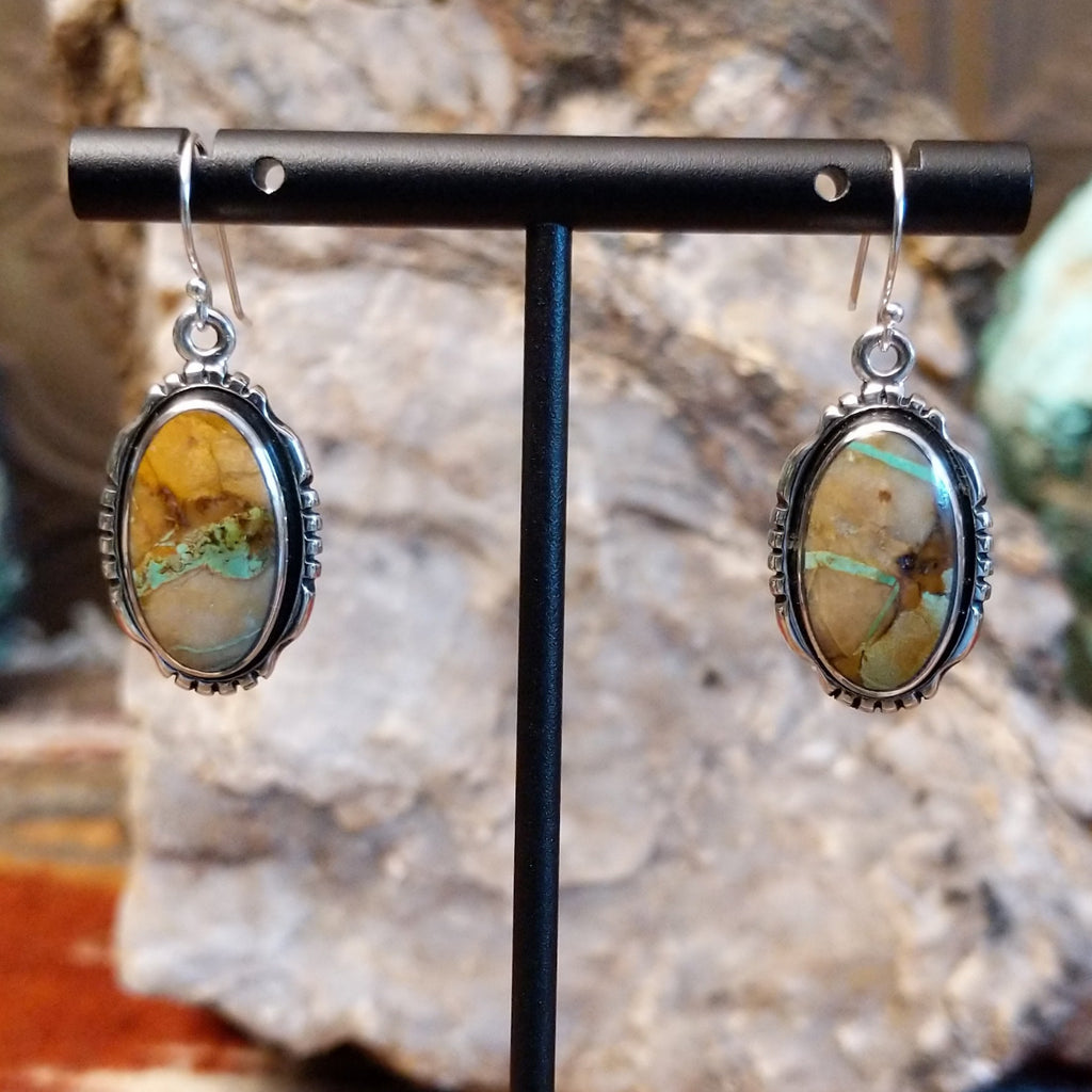 Boulder turquoise set in sterling silver bezels of the earrings with serrations.