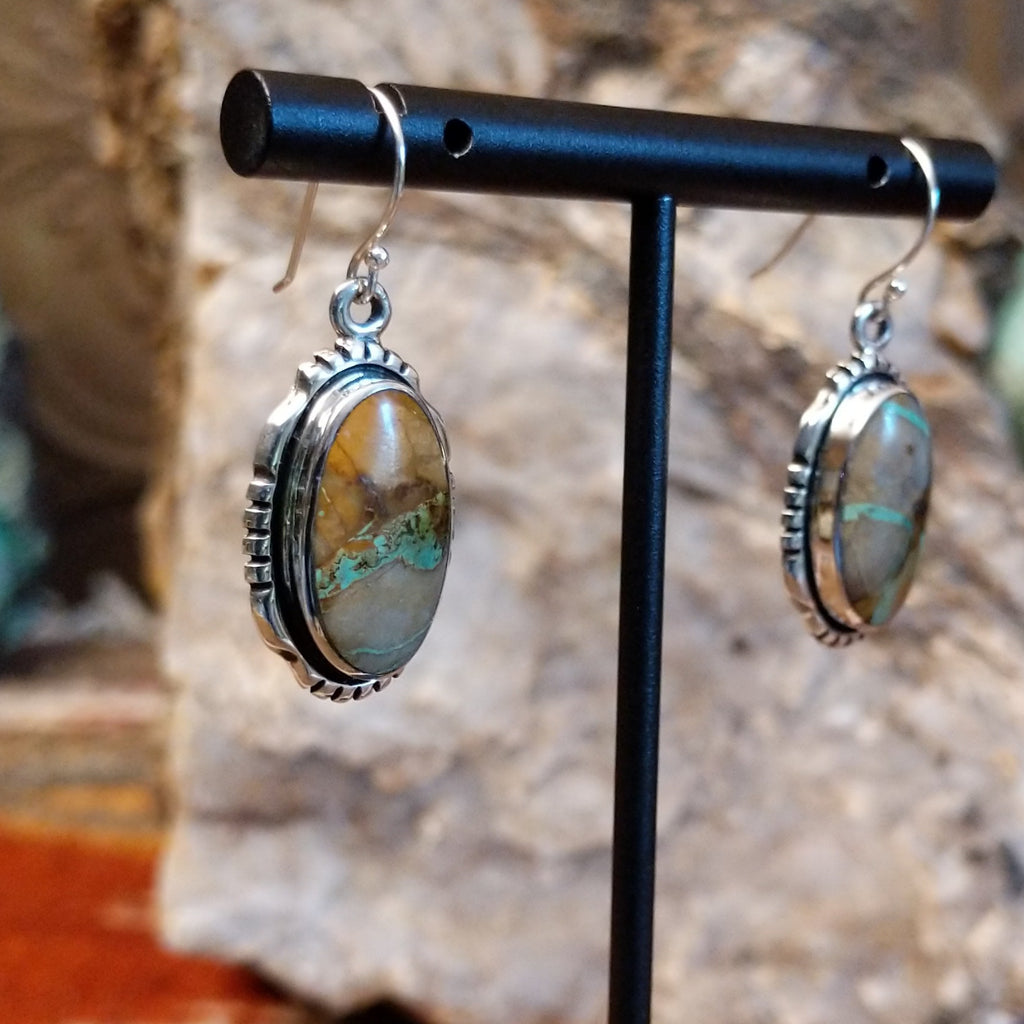 Boulder turquoise set in sterling silver bezels of the earrings with serrations.