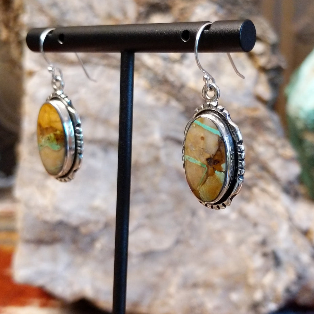 Boulder turquoise set in sterling silver bezels of the earrings with serrations.