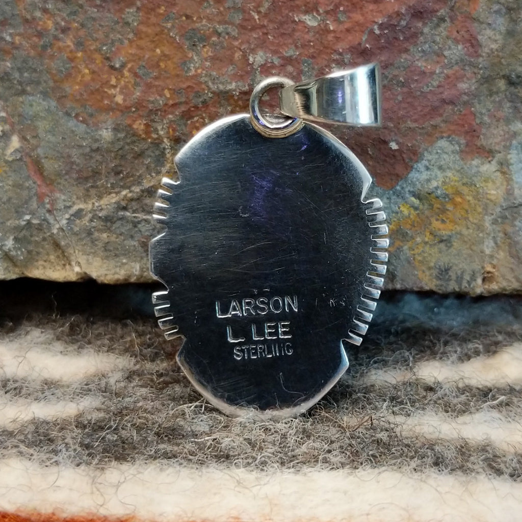 The back of the pendant features the artisan's signature.