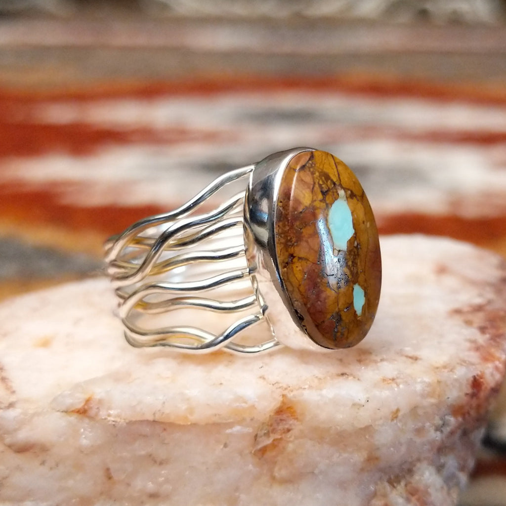 Sterling silver ring with oval boulder turquoise set in the bezel and layered wire band.