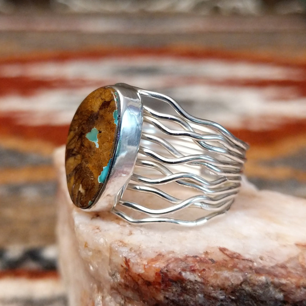 Sterling silver ring with boulder turquoise set in the smooth bezel and layered wire band.