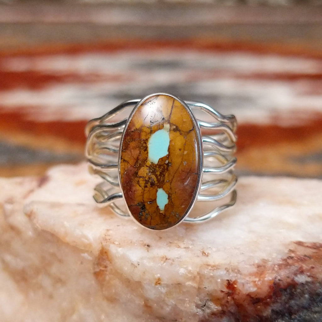 Sterling silver ring with oval boulder turquoise set in the bezel and layered wire band.