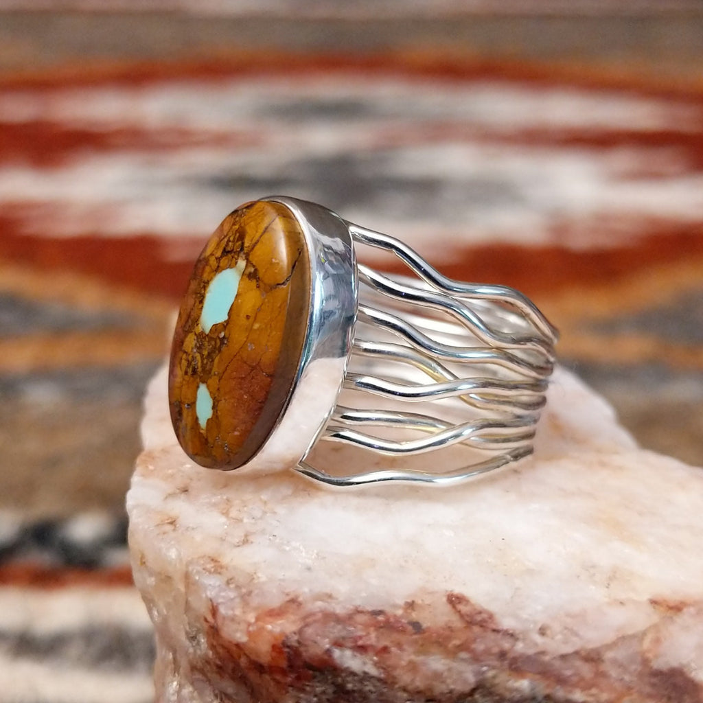 Sterling silver ring with oval boulder turquoise set in the bezel and layered wire band.