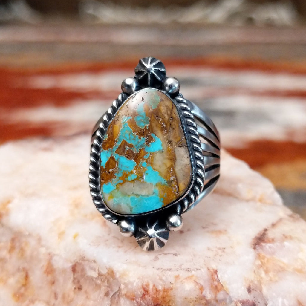 Ornate sterling silver ring with boulder turquoise set in a twisted rope bezel.