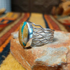 Boulder Turquoise Strand Ring by Angela Martin featuring a natural turquoise stone set in sterling silver, size 8, approximately 0.75 inches long and 0.875 inches wide. Handcrafted jewelry piece with distinctive turquoise patterns; side view.