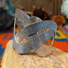 Wide silver cuff by Ryan Sanchez with interwoven textured bands and open braided design.