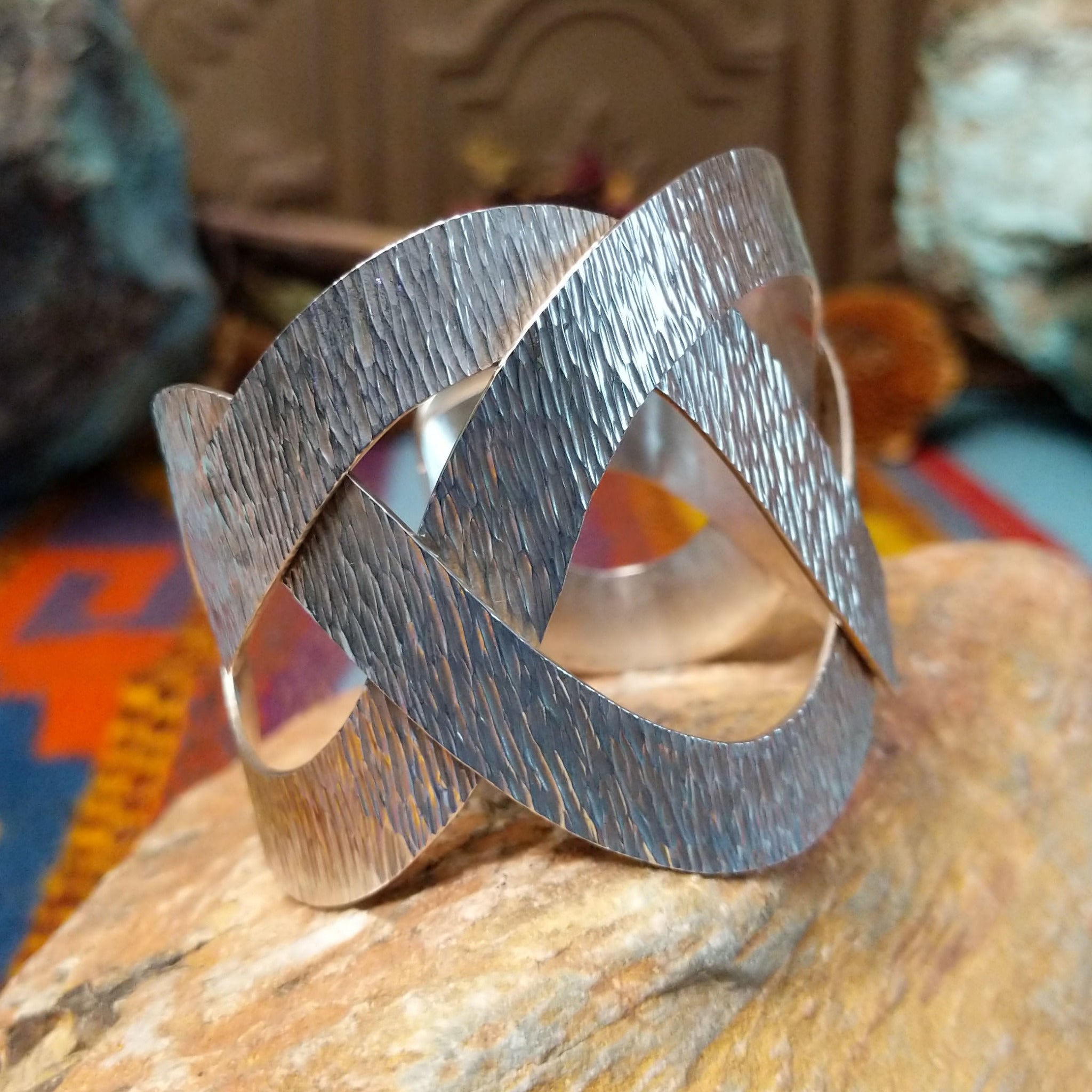 Wide silver cuff by Ryan Sanchez with interwoven textured bands and open braided design.
