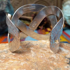 Wide silver cuff by Ryan Sanchez with interwoven textured bands and open braided design.