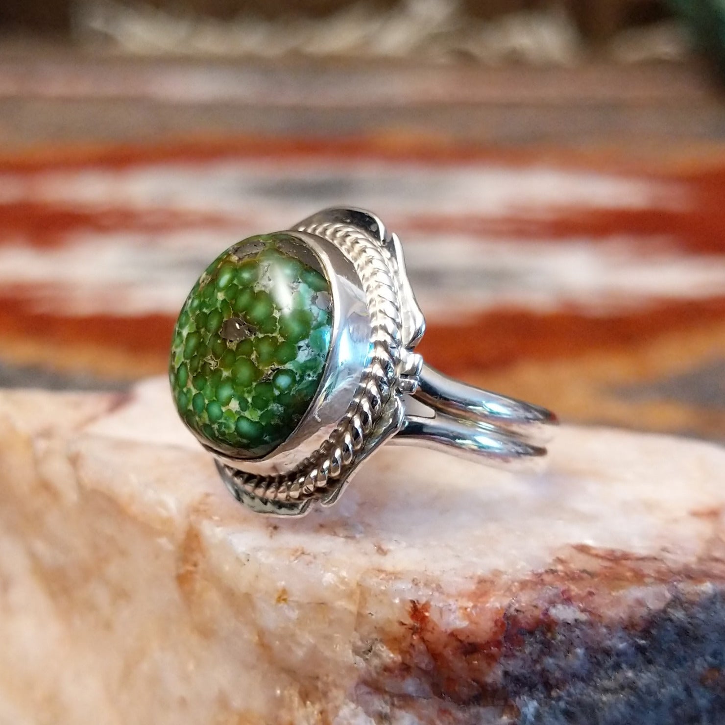 Sterling silver ring with sonoran gold turquoise framed by twisted rope accents and ornate details.