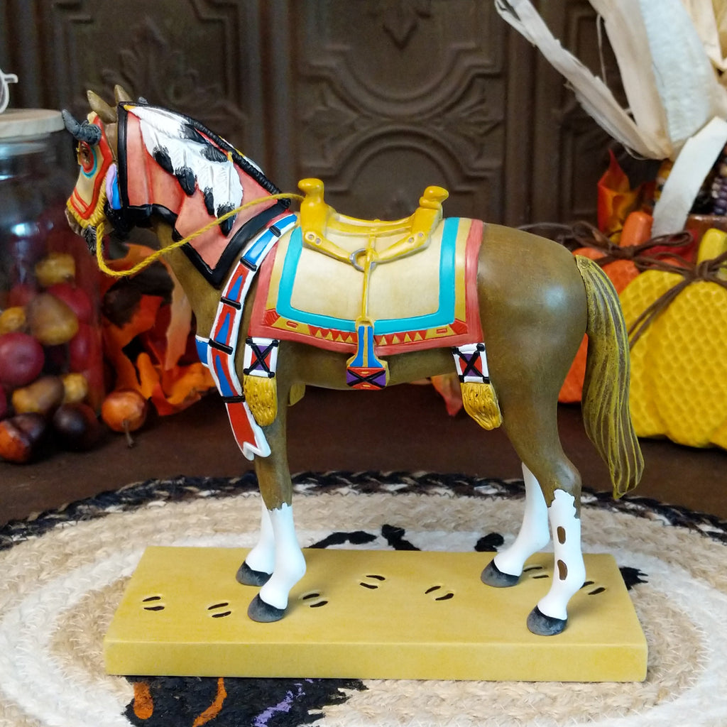 Resin pony painted brown with white accents featuring a horned face shield and colorful tack.