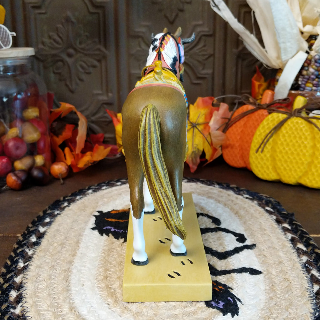 Resin pony painted brown with white accents featuring a horned face shield and colorful tack.