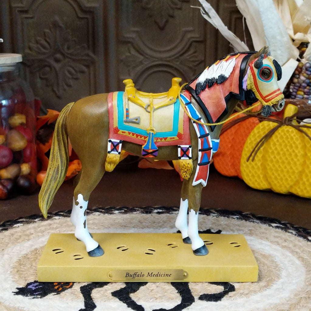Resin pony painted brown with white accents featuring a horned face shield and colorful tack.
