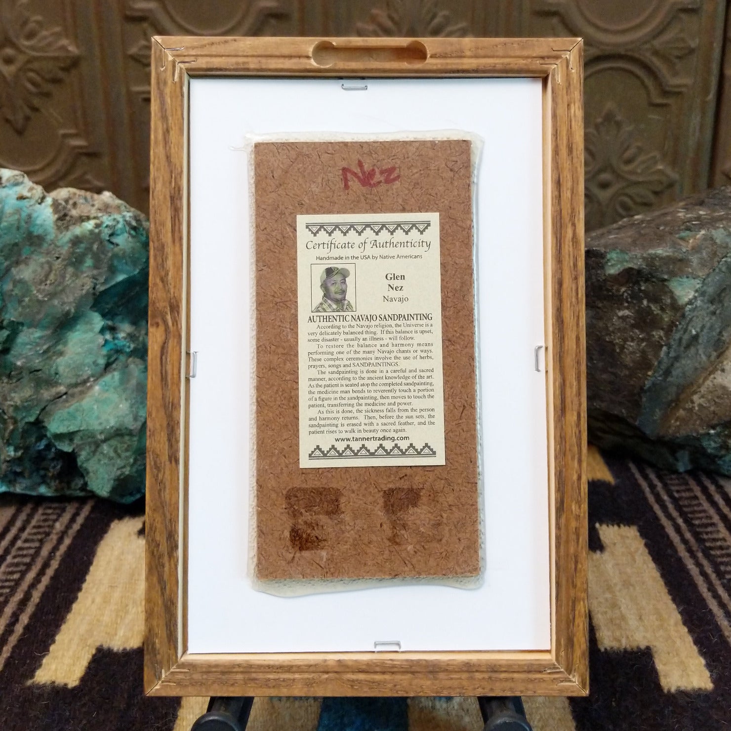 Backside of the Buffalo sand painting, showing the Certificate of Authenticity and Artist information. 