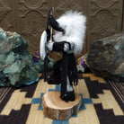 Navajo-made Buffalo Warrior kachina doll by M. C. with black garments, white fur collar, bow and arrow, and painted shield.