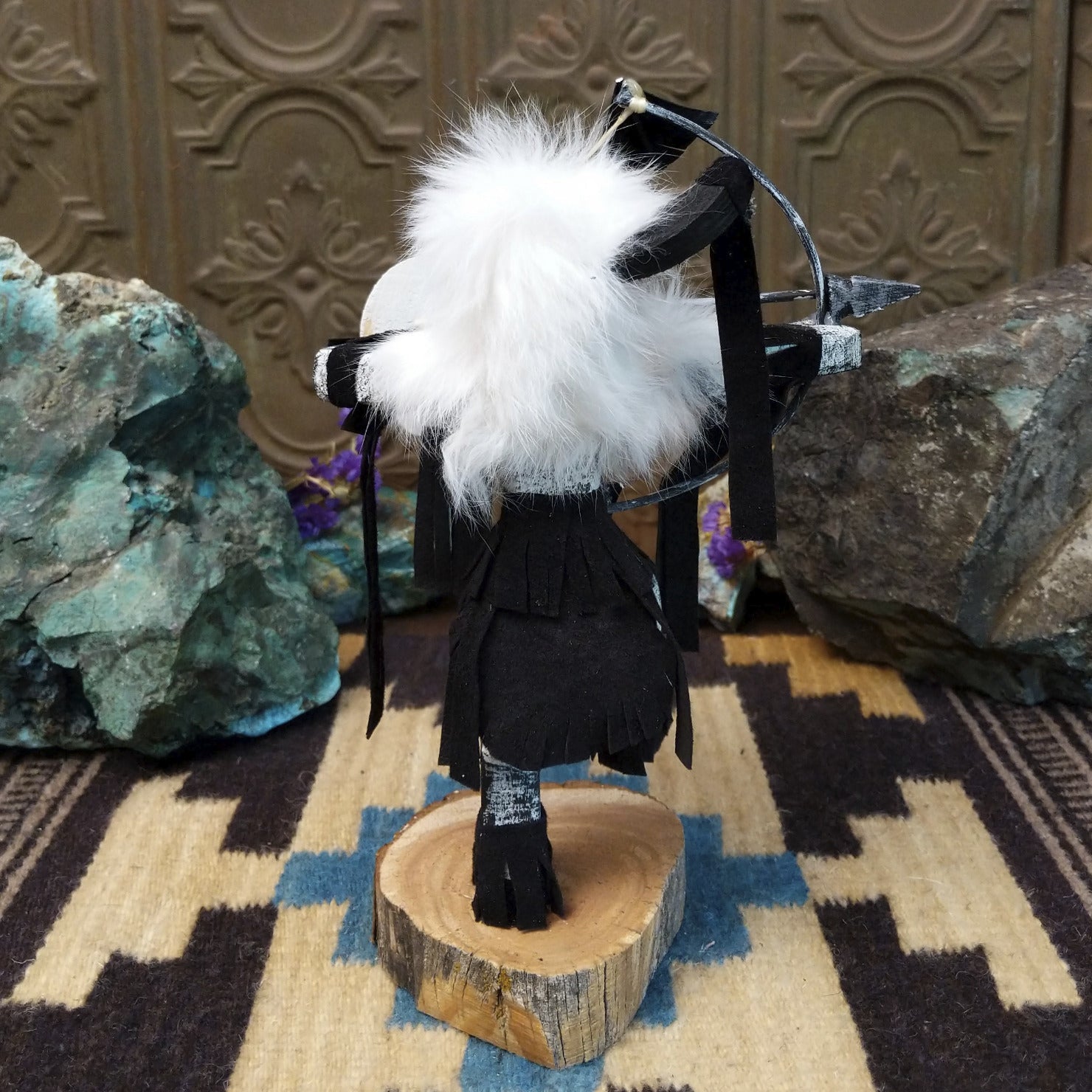 Navajo-made Buffalo Warrior kachina doll by M. C. with black garments, white fur collar, bow and arrow, and painted shield.