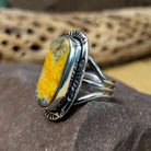 Bumblebee jasper capsule ring by Terry Wood, featuring a capsule-shaped bumblebee jasper stone with natural yellow, orange, black, and gray patterns set in a handcrafted sterling silver band.  Side view.
