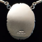 The back features the artisan's signature.