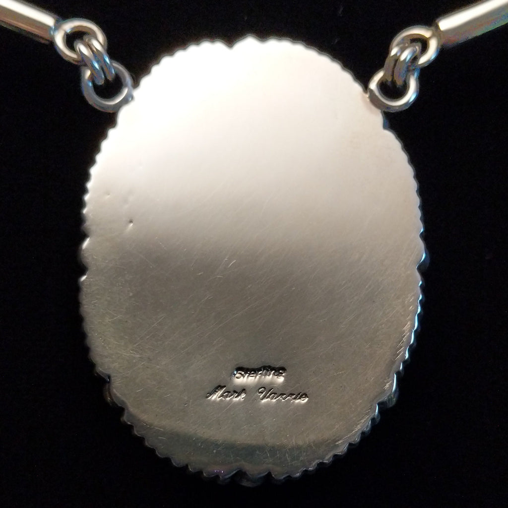 The back features the artisan's signature.