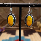 Sterling silver earrings with bumblebee jasper set in oval bezels, framed by incised lining.