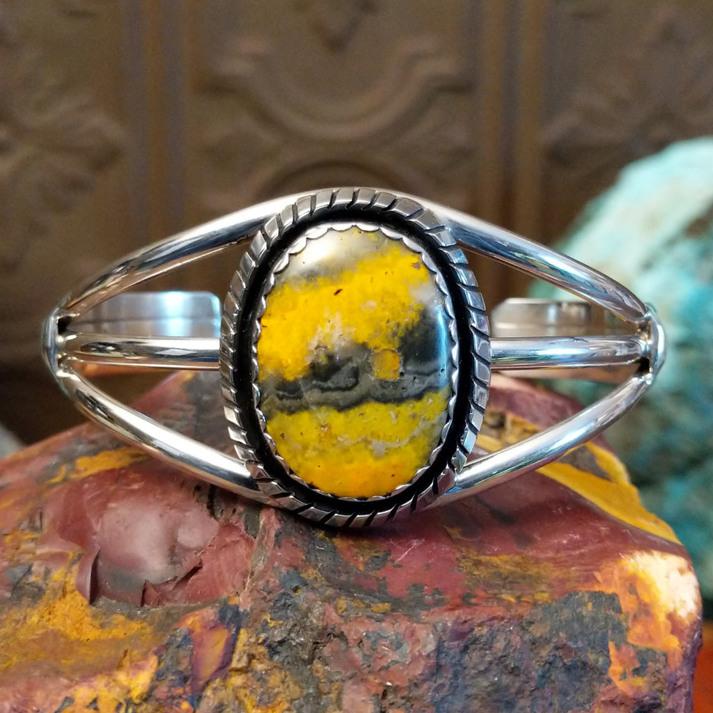 Bumblebee jasper set in a scalloped bezel with ridged frame and tri-layered band.