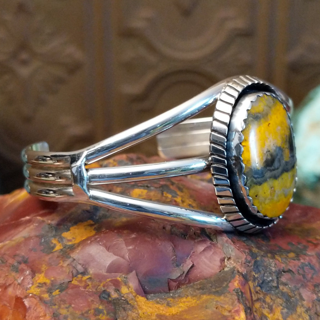 Bumblebee jasper set in a scalloped bezel with ridged frame and tri-layered band.