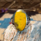 Sterling silver ring with bumblebee jasper set in an oval bezel and ornate stamping on the band.