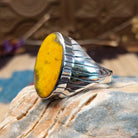 Sterling silver ring with bumblebee jasper set in an oval bezel and ornate stamping on the band.