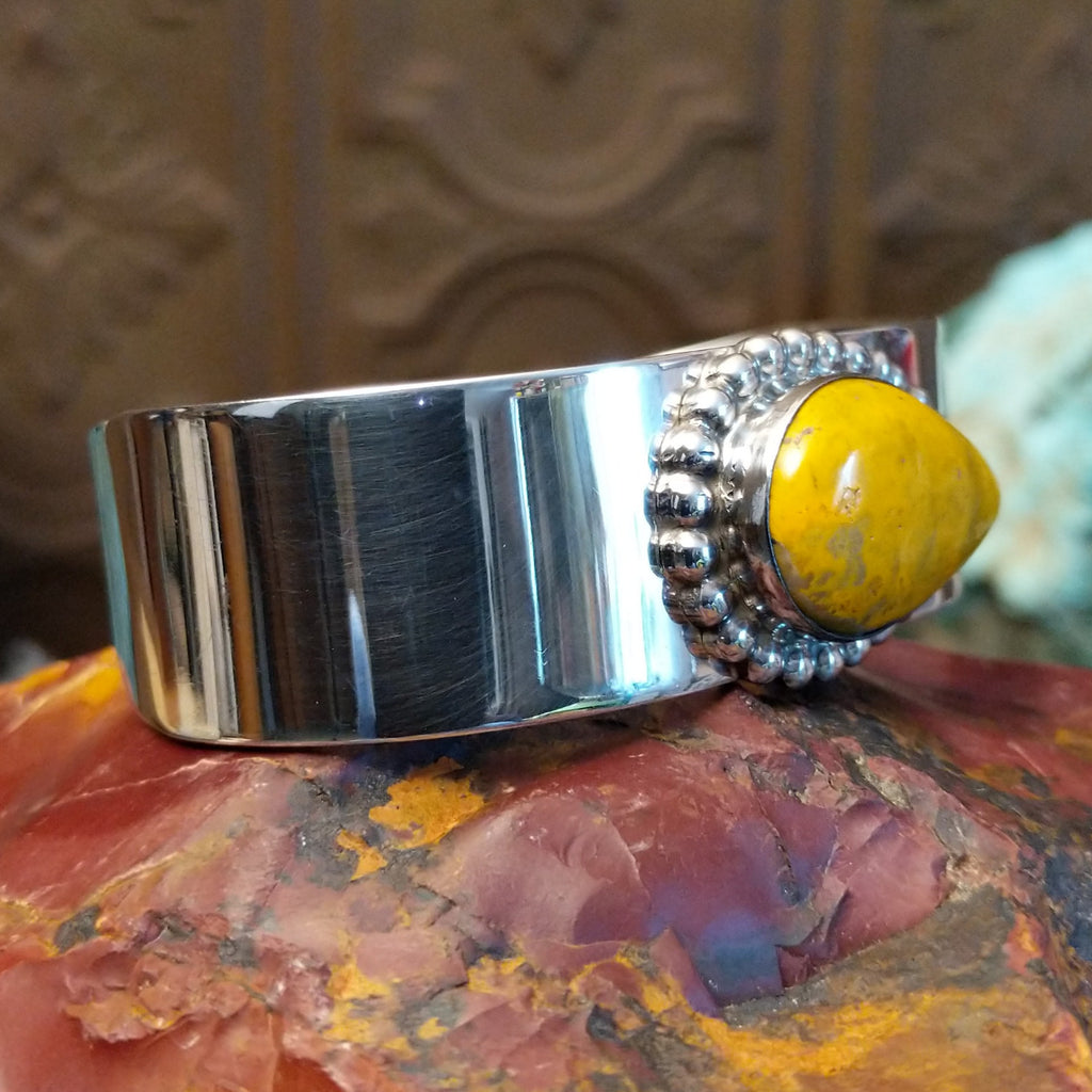 Teardrop shaped bumblebee jasper framed by dotted accents on a polished sterling silver band.