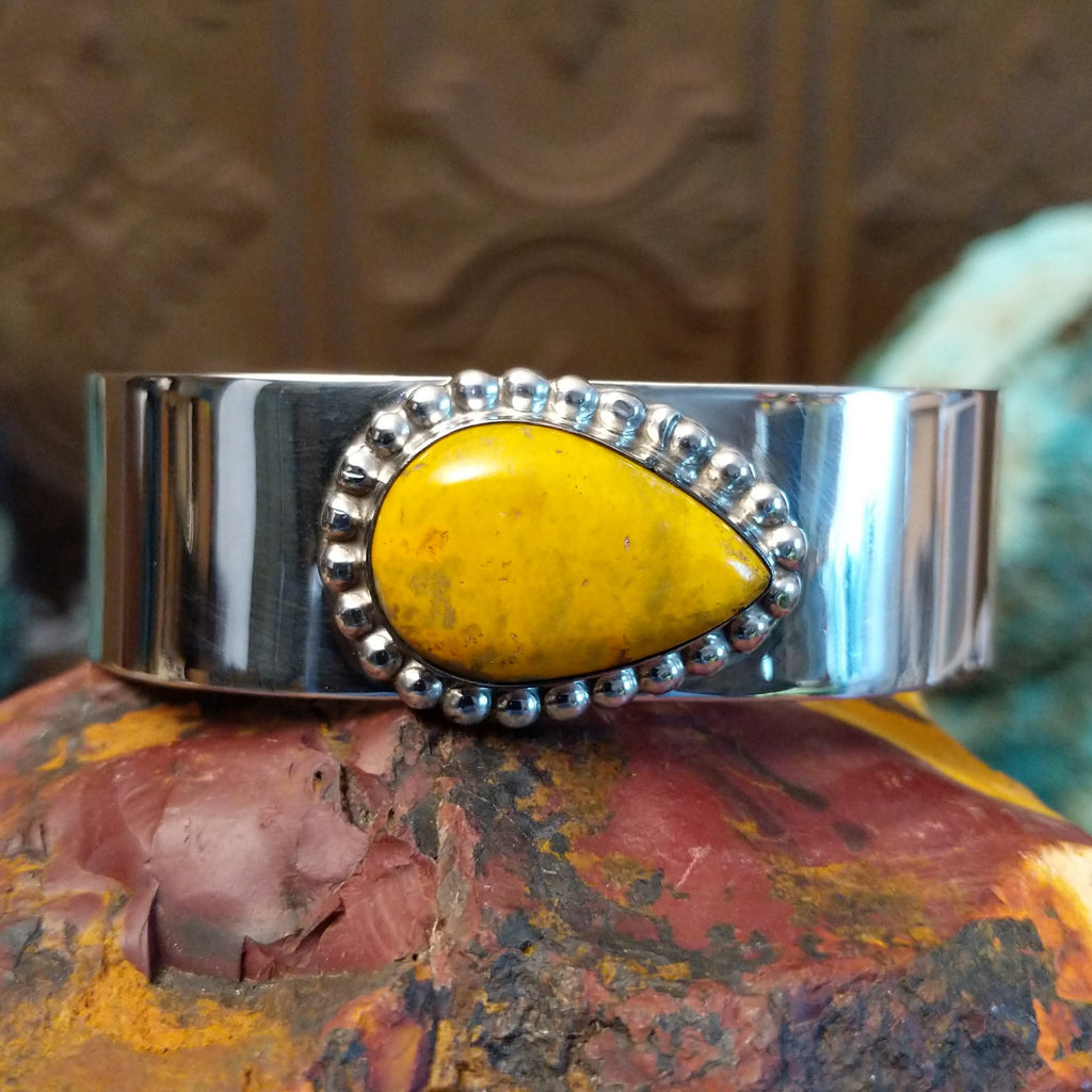 Teardrop shaped bumblebee jasper framed by dotted accents on a polished sterling silver band.