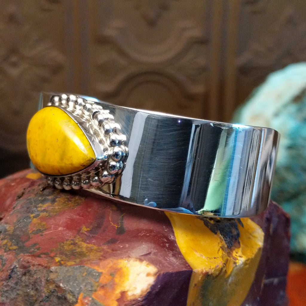 Teardrop shaped bumblebee jasper framed by dotted accents on a polished sterling silver band.