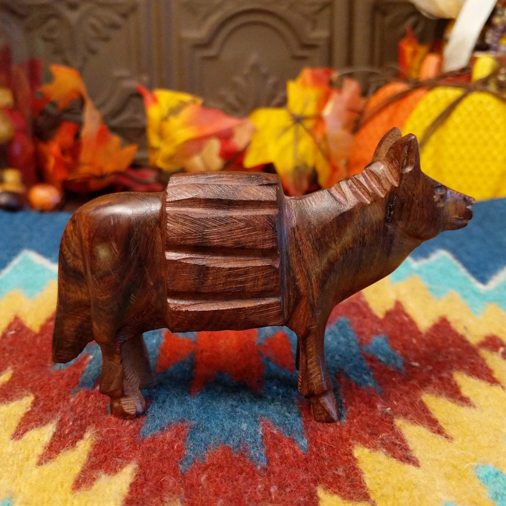 Ironwood carved into a donkey carrying a pack on its back.