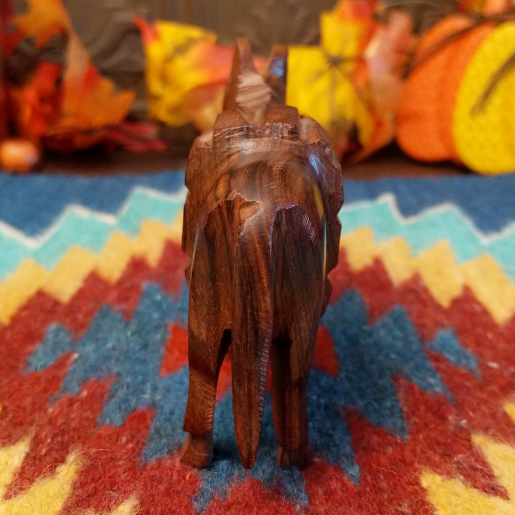 Ironwood carved into a donkey carrying a pack on its back.