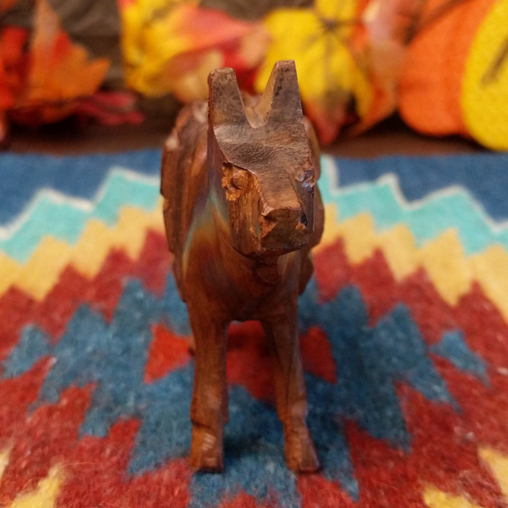 Ironwood carved into a donkey carrying a pack on its back.