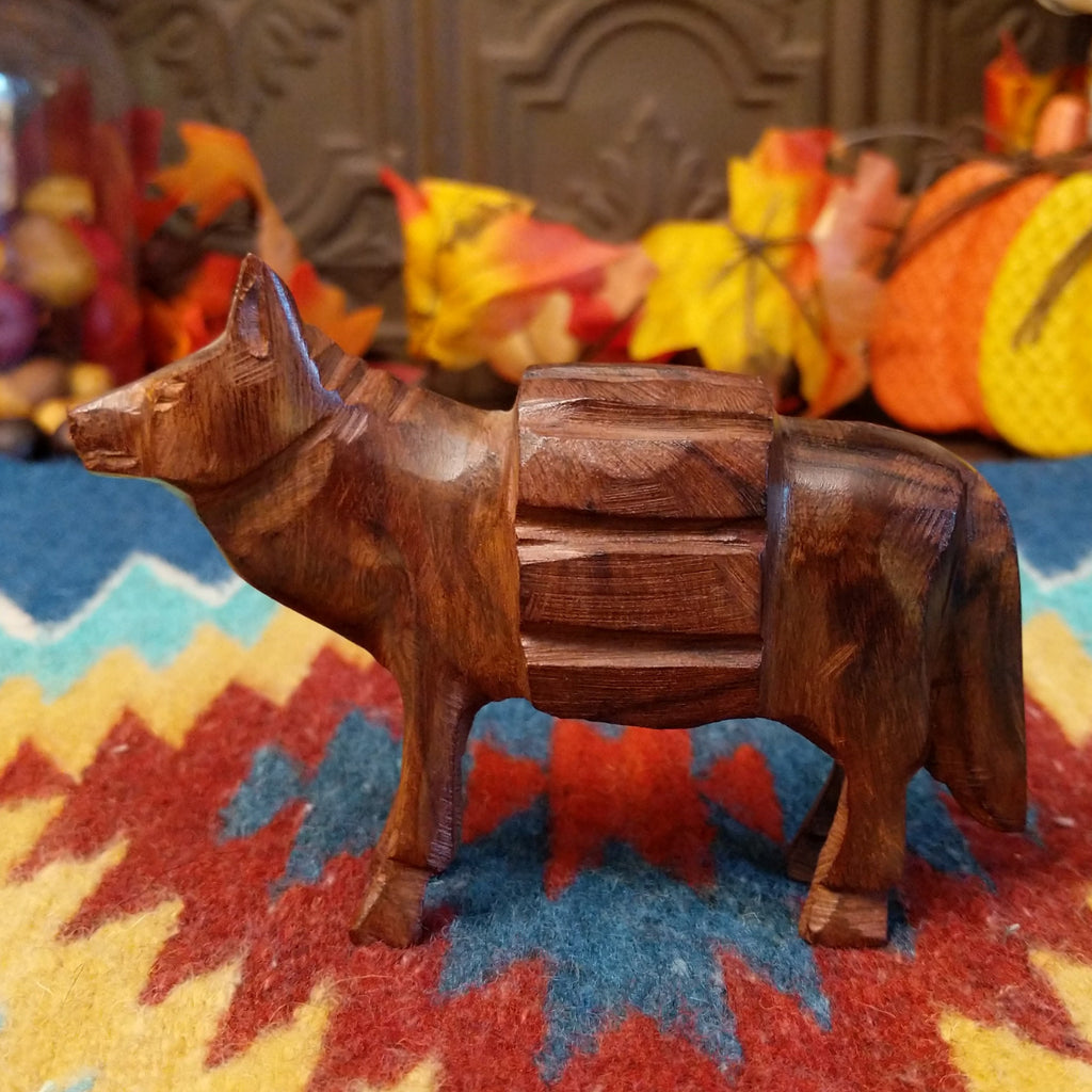 Ironwood carved into a donkey carrying a pack on its back.