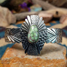 Handcrafted sterling silver shield cuff by Benjamin Piaso featuring an oval Carico Lake turquoise cabochon with ornate silver beadwork, scroll accents, blossom details, and an openwork design.