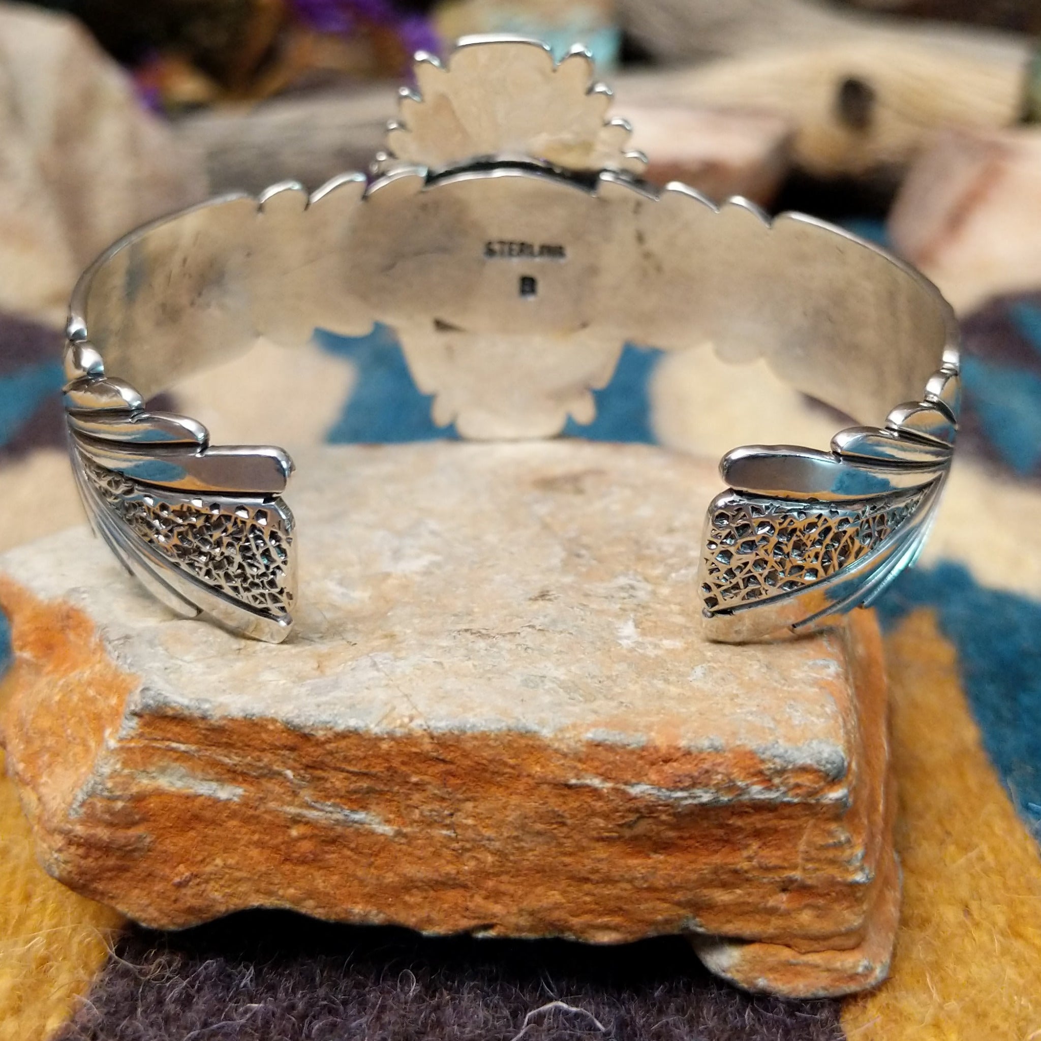 Handcrafted sterling silver shield cuff by Benjamin Piaso featuring an oval Carico Lake turquoise cabochon with ornate silver beadwork, scroll accents, blossom details, and an openwork design; underside view.