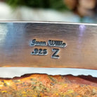 Close-up of the artisan's stamped signature.