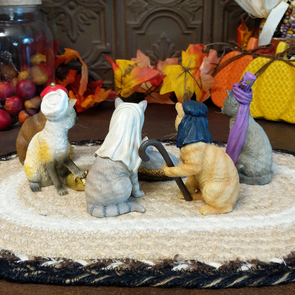 Resin cats creating a nativity scene in various colors and accents.