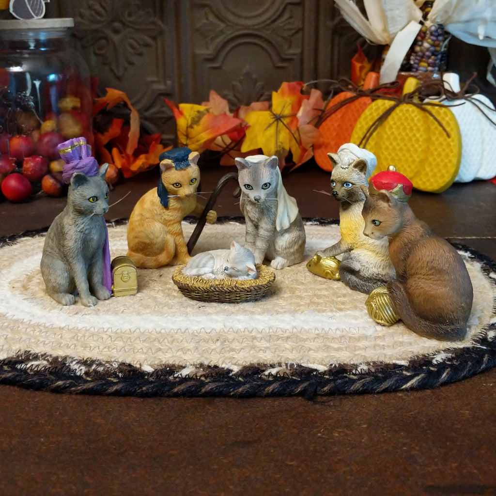 Resin cats creating a nativity scene in various colors and accents.