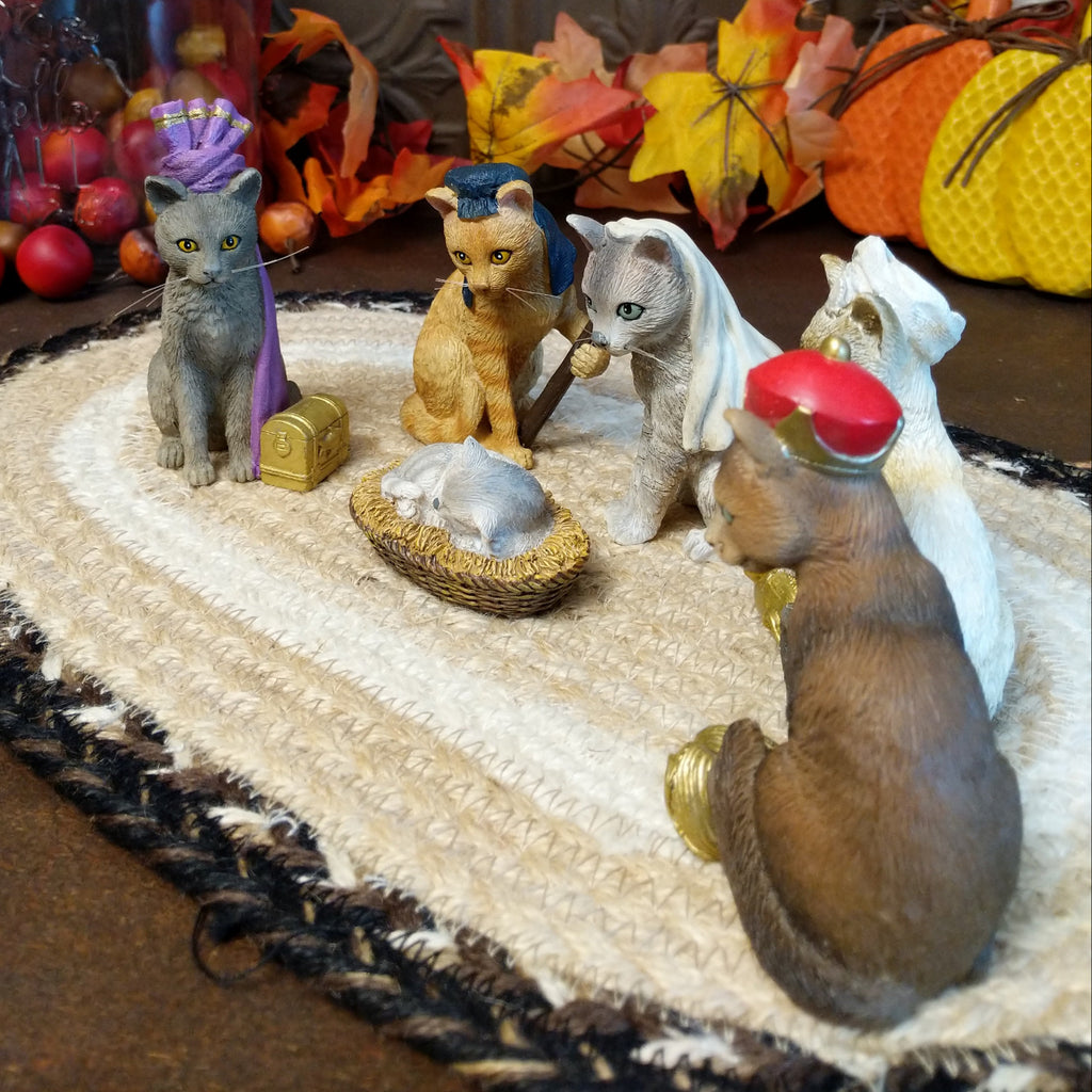Resin cats creating a nativity scene in various colors and accents.